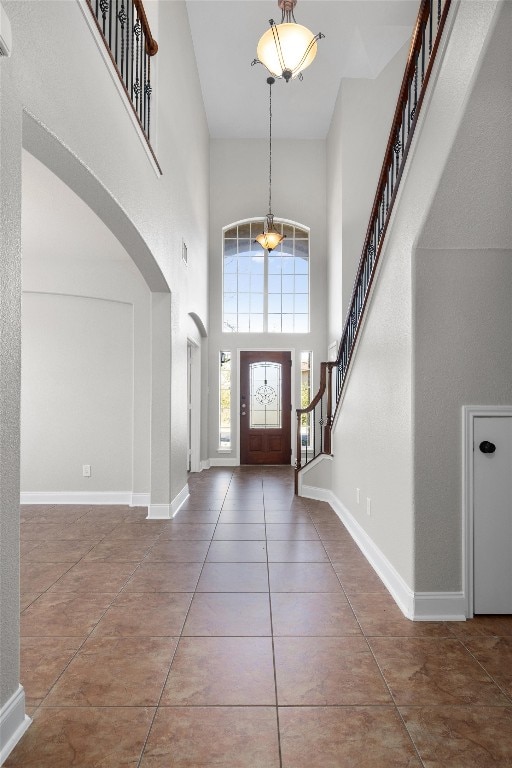 tiled entryway featuring a towering ceiling