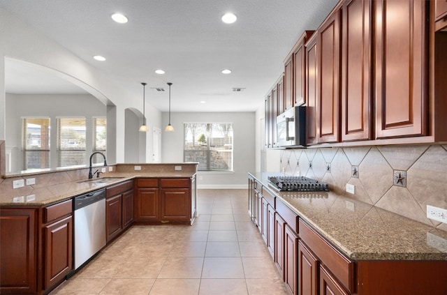 kitchen with tasteful backsplash, stainless steel appliances, sink, light tile patterned floors, and hanging light fixtures