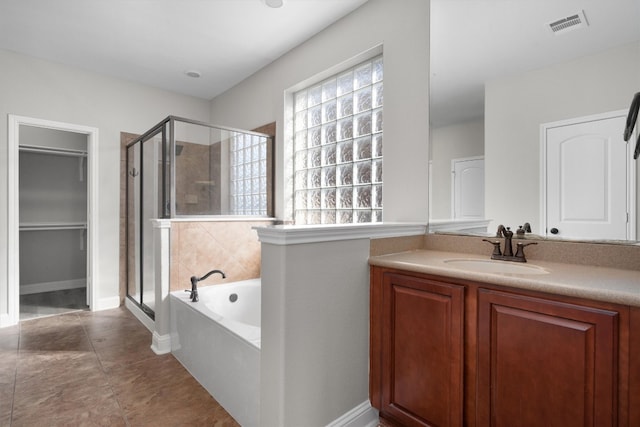 bathroom featuring vanity and independent shower and bath