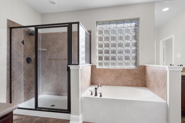 bathroom featuring vanity, separate shower and tub, and a wealth of natural light