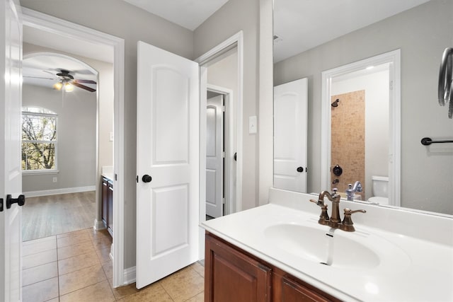 bathroom featuring tile patterned floors, walk in shower, vanity, ceiling fan, and toilet