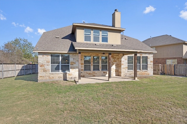 back of house featuring a lawn and a patio area