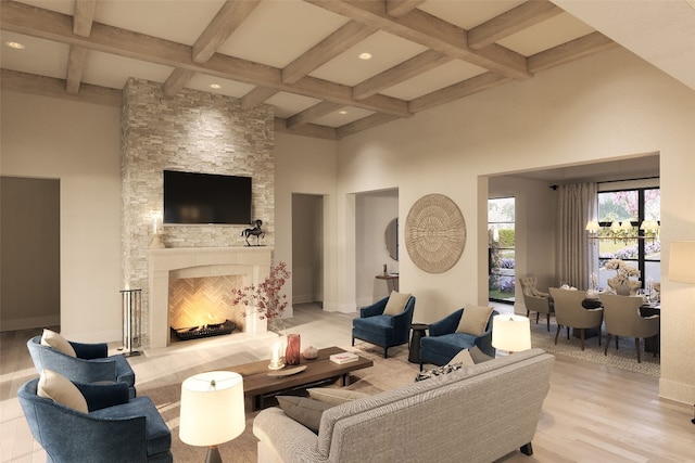 living room featuring beam ceiling, coffered ceiling, a high ceiling, light hardwood / wood-style flooring, and a fireplace