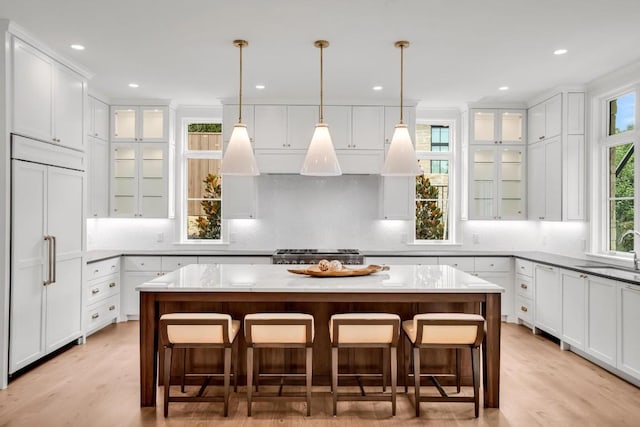 kitchen with a kitchen island, paneled refrigerator, and a kitchen bar