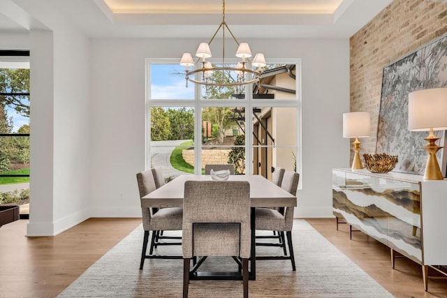 dining room featuring hardwood / wood-style floors, a wealth of natural light, and a raised ceiling