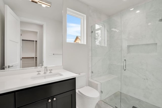 bathroom with toilet, vanity, and walk in shower