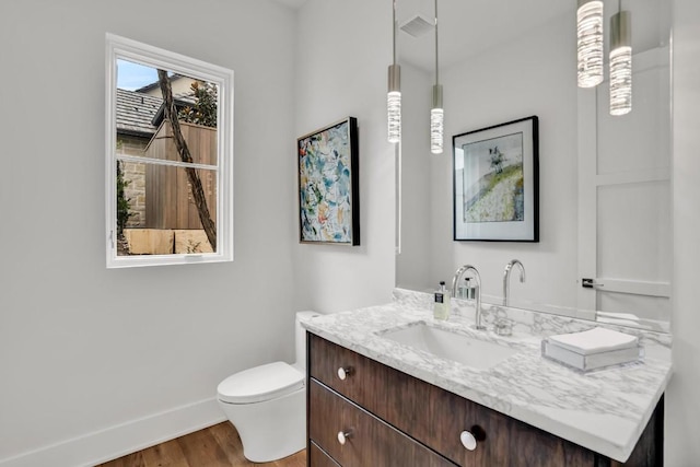 bathroom with vanity, wood-type flooring, and toilet