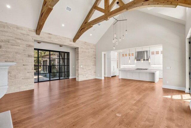 4312 Amarra Dr, Austin, TX 78735 - unfurnished living room featuring high vaulted ceiling, visible vents, light wood finished floors, baseboards, and beam ceiling