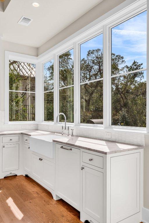 4312 Amarra Dr, Austin, TX 78735 - kitchen featuring white cabinetry, a sink, light stone counters, and visible vents