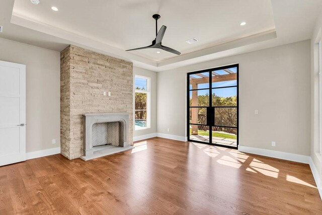 4312 Amarra Dr, Austin, TX 78735 - unfurnished living room with a ceiling fan, a raised ceiling, a stone fireplace, and wood finished floors