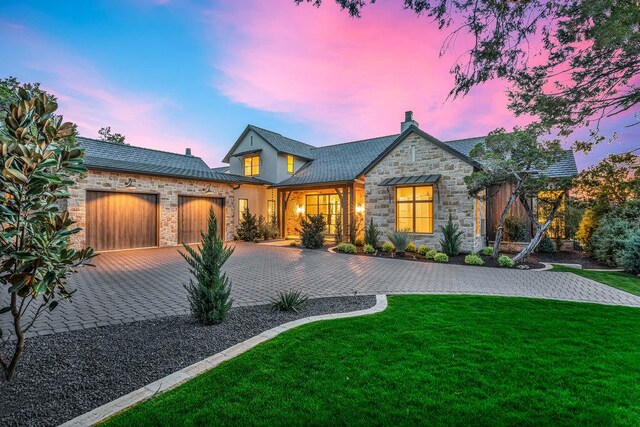 4312 Amarra Dr, Austin, TX 78735 - rear view of house featuring a chimney, stone siding, decorative driveway, a garage, and a lawn