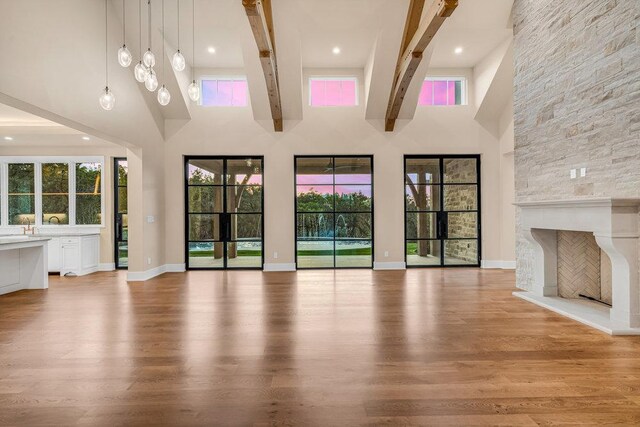 4312 Amarra Dr, Austin, TX 78735 - unfurnished living room with light wood finished floors, baseboards, a stone fireplace, and a high ceiling