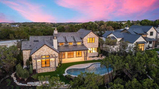 4312 Amarra Dr, Austin, TX 78735 - back of property featuring a chimney, stone siding, an outdoor pool, and a patio