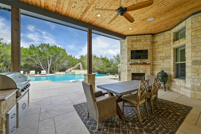 12920 Zen Gardens Way, Austin, TX 78732 - view of patio / terrace with area for grilling, an outdoor stone fireplace, outdoor dining space, ceiling fan, and an outdoor pool