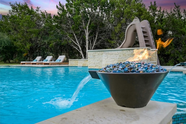 pool at dusk with pool water feature