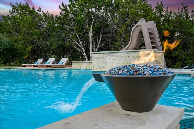 12920 Zen Gardens Way, Austin, TX 78732 - pool at dusk with an outdoor pool and view of wooded area