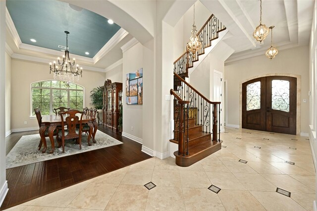 12920 Zen Gardens Way, Austin, TX 78732 - foyer entrance with arched walkways, a chandelier, a raised ceiling, french doors, and stairway