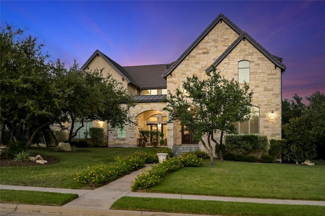 12920 Zen Gardens Way, Austin, TX 78732 - view of front of property with a lawn, stone siding, and a standing seam roof