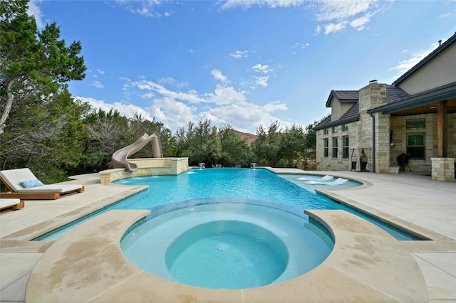 view of pool with an in ground hot tub, a patio, and a water slide