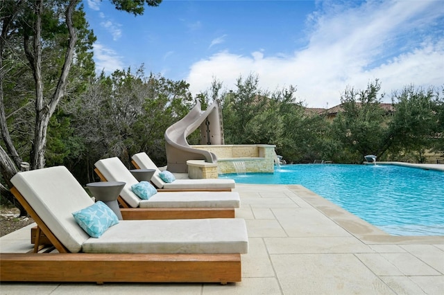 view of swimming pool featuring pool water feature, a patio area, and a water slide