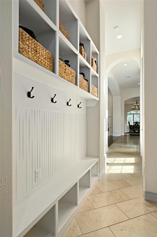 mudroom with tile patterned flooring and a chandelier