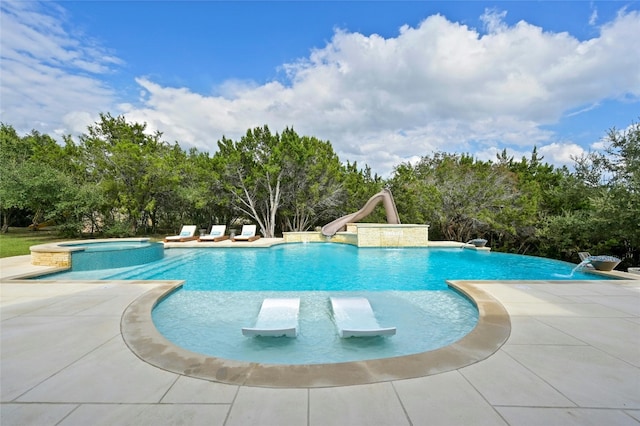 view of swimming pool featuring an in ground hot tub, pool water feature, and a water slide