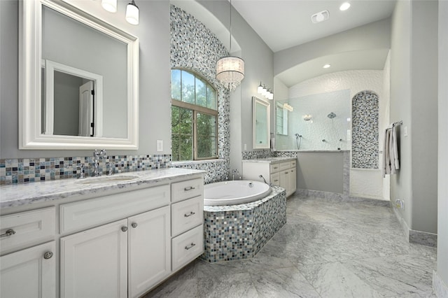 bathroom featuring tiled bath and vanity