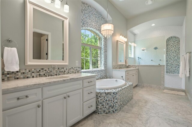 12920 Zen Gardens Way, Austin, TX 78732 - bathroom featuring walk in shower, two vanities, a garden tub, tasteful backsplash, and a chandelier