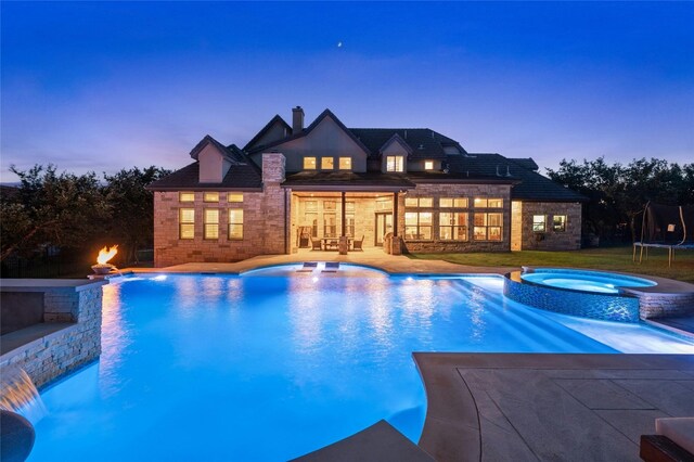 12920 Zen Gardens Way, Austin, TX 78732 - pool at dusk featuring a pool with connected hot tub, a trampoline, and a patio area