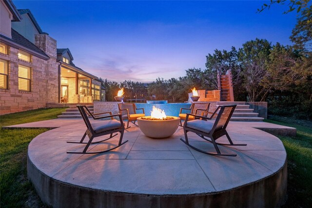 12920 Zen Gardens Way, Austin, TX 78732 - patio terrace at dusk featuring stairway, a fire pit, and a patio