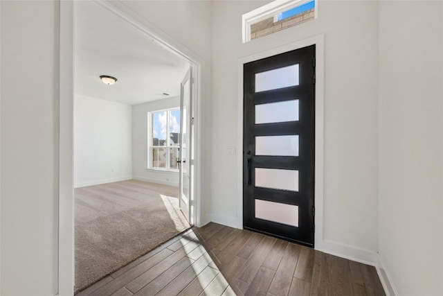 foyer featuring baseboards and wood finished floors