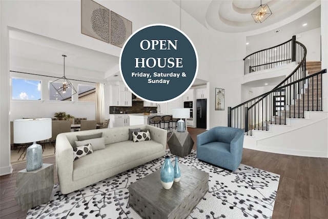 1205 Summer Moon Dr, Georgetown, TX 78628 - living room with a chandelier, stairway, wood finished floors, a towering ceiling, and baseboards