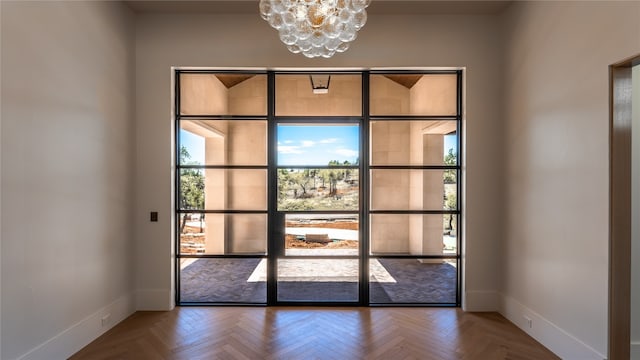 entryway with a notable chandelier and parquet flooring