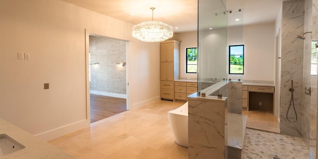 full bathroom featuring a freestanding bath, a marble finish shower, vanity, and an inviting chandelier