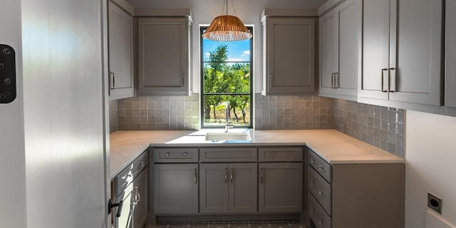 kitchen with pendant lighting, light stone countertops, and gray cabinetry