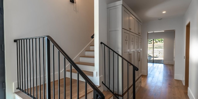 stairs featuring recessed lighting, wood finished floors, and baseboards