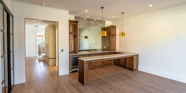 bathroom featuring tasteful backsplash, baseboards, wood finished floors, a sink, and recessed lighting