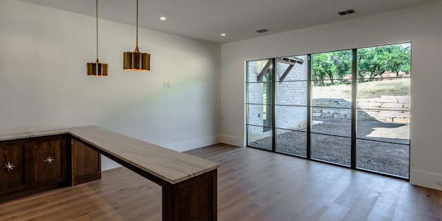 doorway to outside featuring baseboards, visible vents, wood finished floors, and recessed lighting