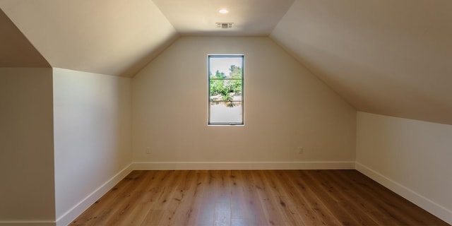 bonus room with vaulted ceiling, light wood-style flooring, visible vents, and baseboards