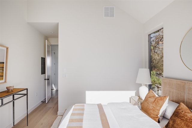 bedroom featuring vaulted ceiling and light wood-type flooring