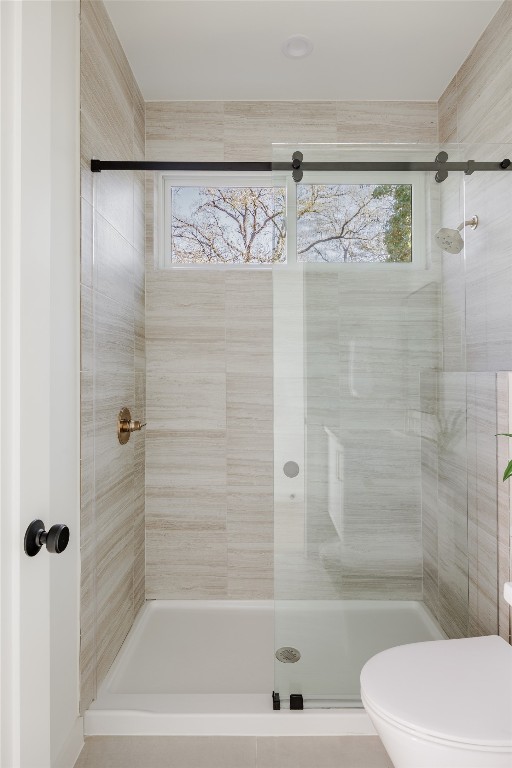 bathroom with toilet and a shower with shower door