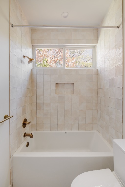 bathroom with tiled shower / bath and toilet