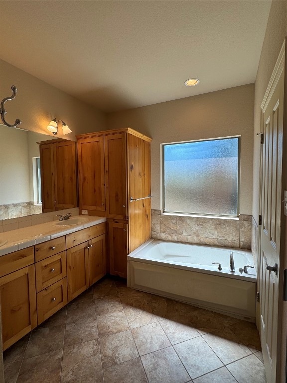 bathroom with tile patterned flooring, vanity, and a bathtub