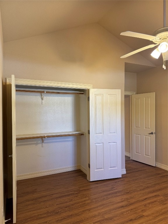 unfurnished bedroom with a closet, ceiling fan, dark hardwood / wood-style flooring, and vaulted ceiling