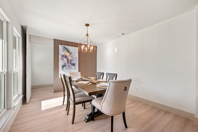 dining room featuring light wood-type flooring and an inviting chandelier