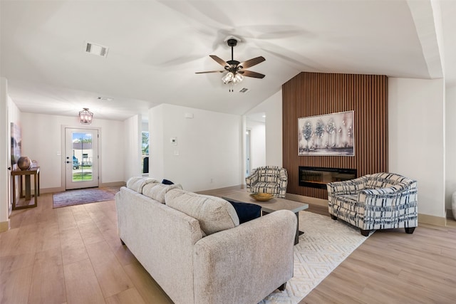 living room with ceiling fan, light hardwood / wood-style flooring, and lofted ceiling