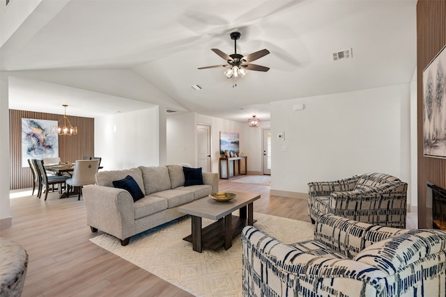 living room featuring ceiling fan with notable chandelier, light hardwood / wood-style floors, and lofted ceiling