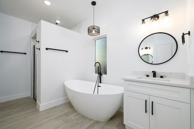 bathroom with wood-type flooring, vanity, shower with separate bathtub, and an inviting chandelier