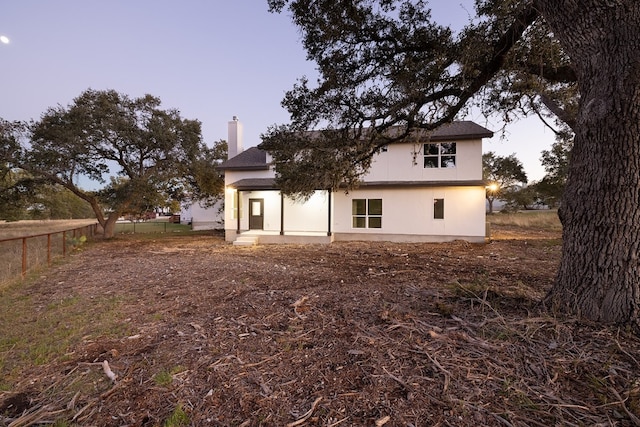 view of back house at dusk