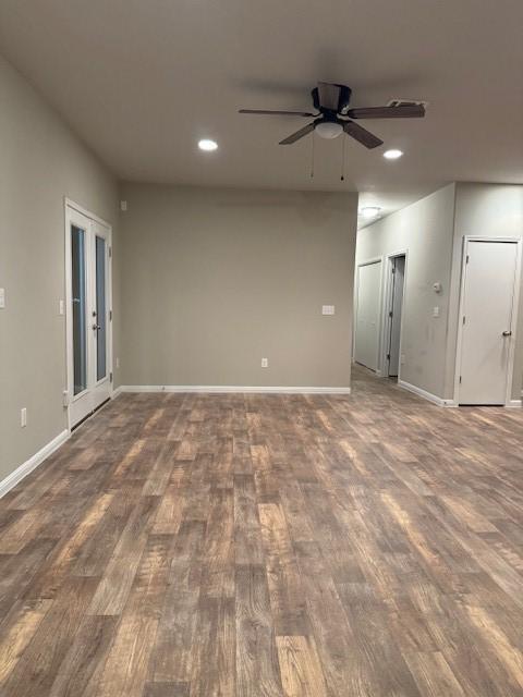 empty room with dark hardwood / wood-style flooring, ceiling fan, and french doors